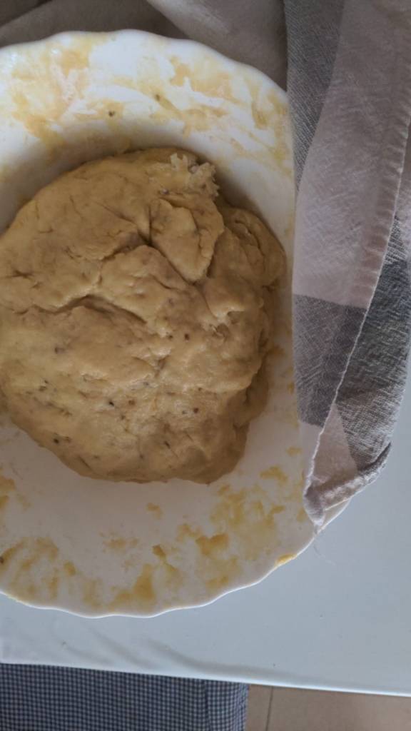 bol blanco con una masa de color amarillo claro. Aquí está suave. Lista para dejarla reposar y amasarla después.